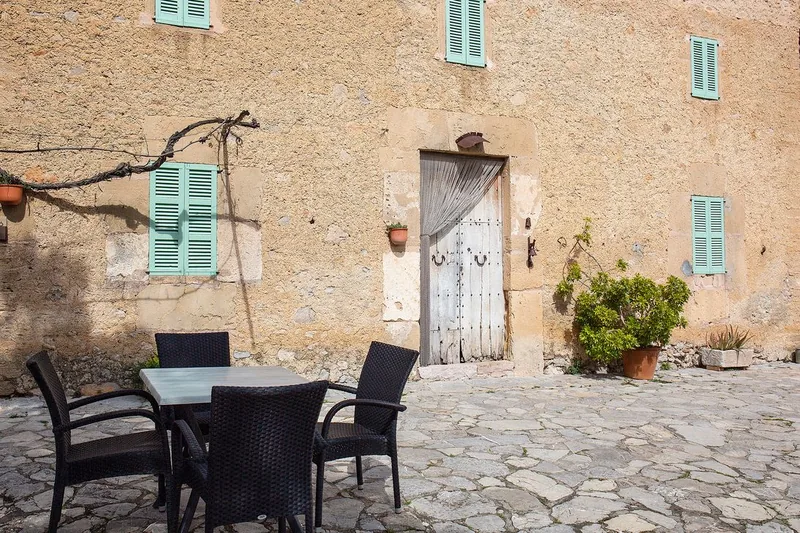Terrace with table beside the stone facade